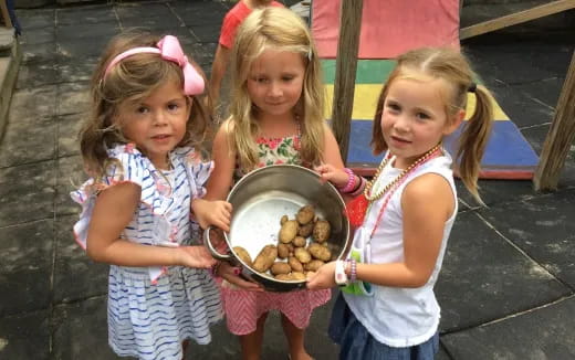 a group of girls holding a bowl of cookies