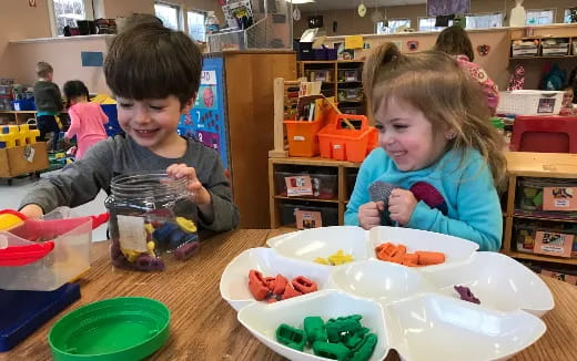 a boy and girl eating at a table