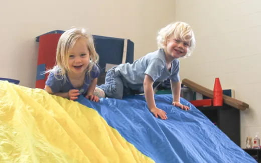 a couple of children sitting on a bed