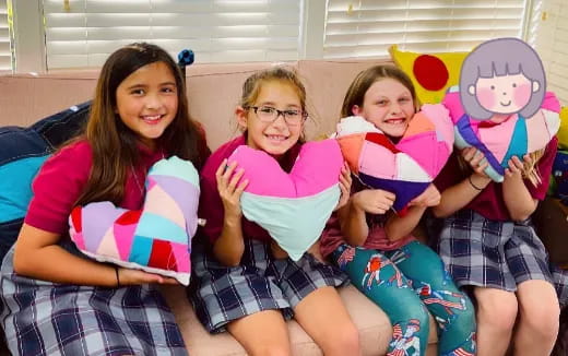 a group of kids sitting on a couch with a stuffed animal