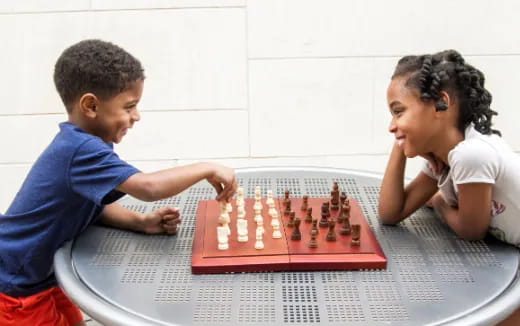 a boy and a girl playing a board game