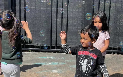 a group of children playing with bubbles