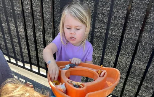 a little girl playing in a bucket