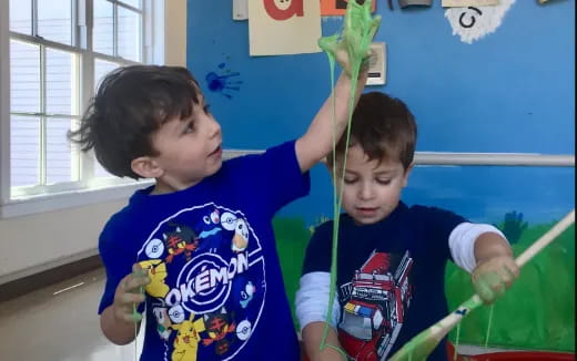 a couple of boys holding a plant