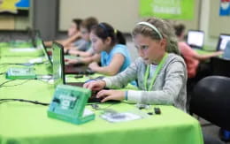 a group of children using laptops