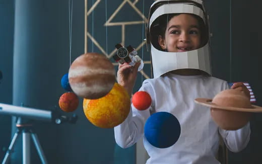 a young boy holding a few balls