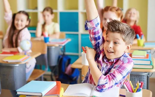 a young boy raising his hand