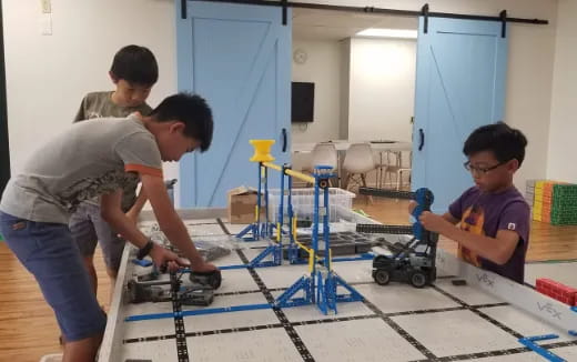 a group of boys working on a robot