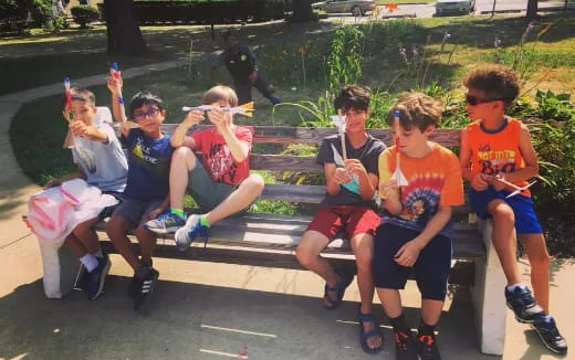a group of kids sitting on a bench