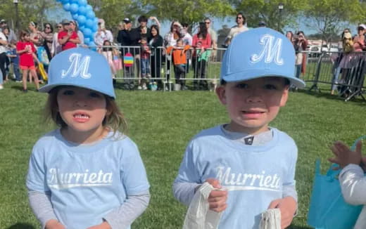 a couple of kids wearing baseball hats