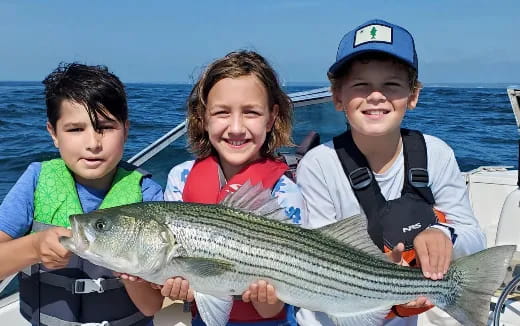 a group of kids holding a fish
