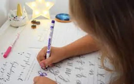 a person writing on a piece of paper