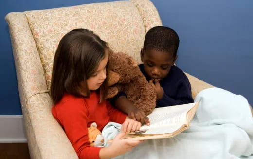 a boy and girl reading a book