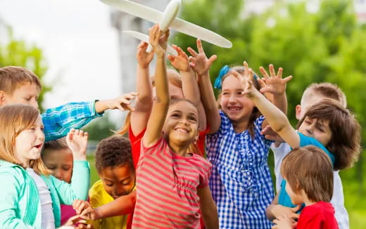 a group of children raising their hands