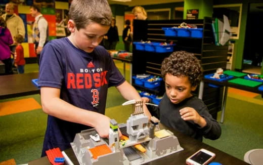 a person and a boy at a table with a model train