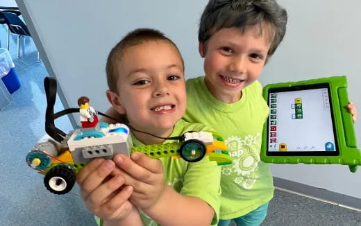 a couple of boys holding a toy car and a toy car