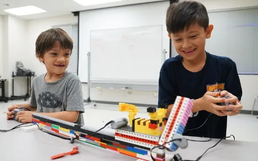 a couple of boys playing with a toy building