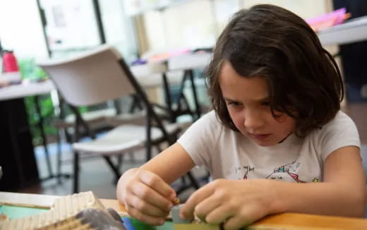 a young girl sitting at a desk