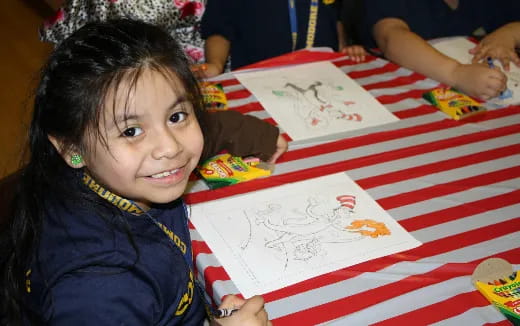 a young girl sitting at a table