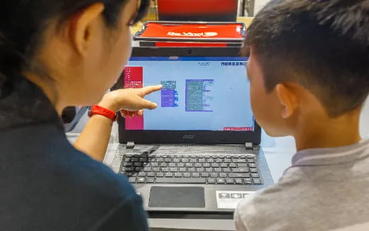 a man pointing at a laptop screen