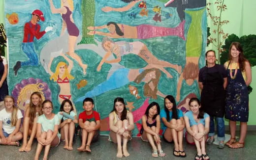 a group of people posing for a photo in front of a wall