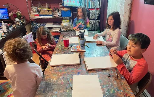 a group of children sitting around a table