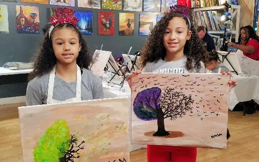 a couple of girls holding art