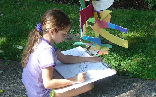 a young girl painting on a paper