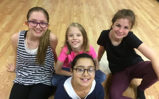 a group of people sitting on a wood floor