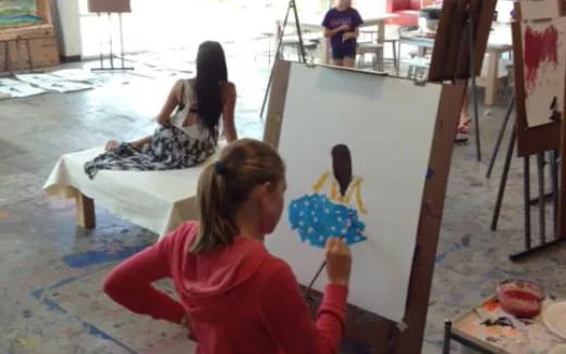 a girl painting on a canvas