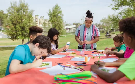 a group of people sitting around a table outside