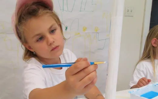 a young girl holding a pen