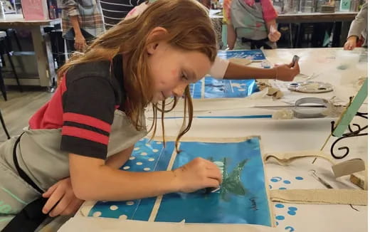 a young girl painting on a table