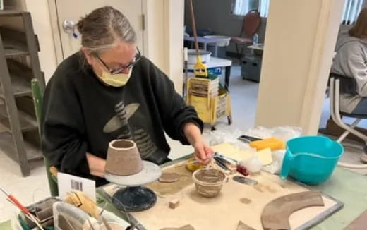 a woman painting a vase