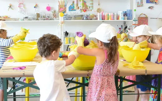 children in a room with yellow buckets and buckets