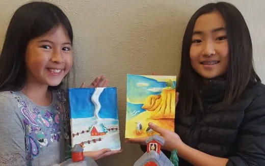 a couple of girls holding a book