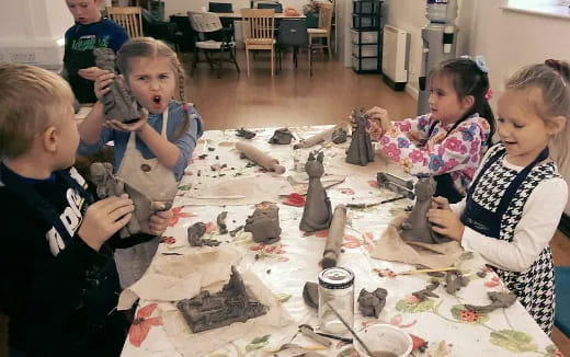 a group of children sitting around a table with objects on it