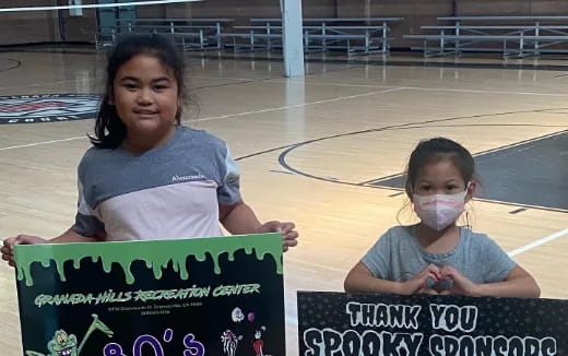 a couple of girls holding a sign