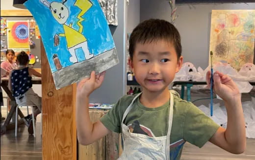 a boy holding a drawing