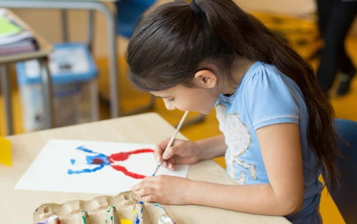 a young girl painting a picture