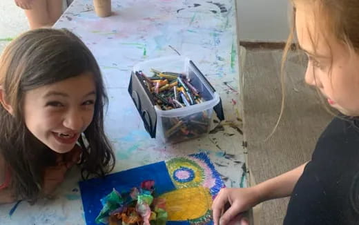 a girl smiling next to a painting