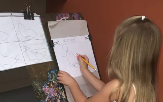 a child drawing on a white board