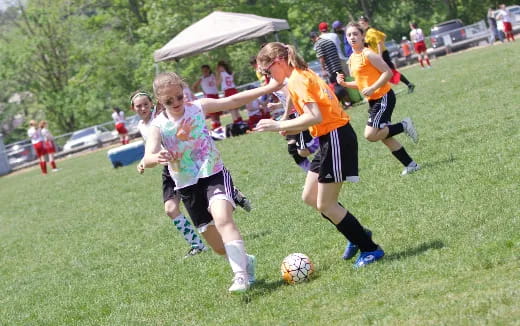 girls playing football on a field