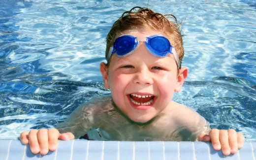 a boy in a pool wearing goggles