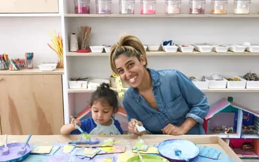 a person and a child sitting at a table with food