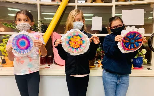 a group of children holding up colorful objects