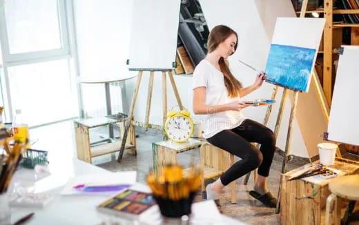 a person painting on a easel