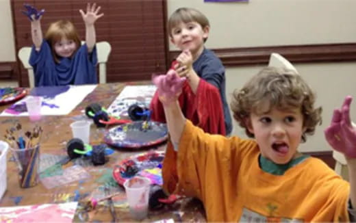 a group of children sitting at a table with toys