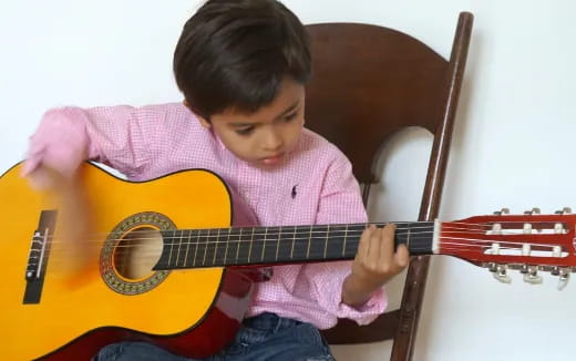 a young boy playing a guitar
