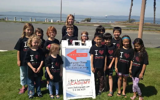 a group of children posing for a photo with a sign